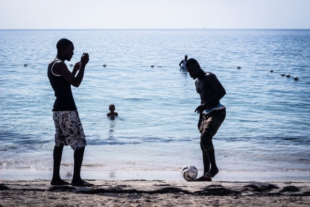 men play football on a beach in Negrill