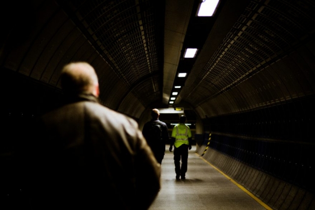 three men walk towards a platform at London Bridge underground